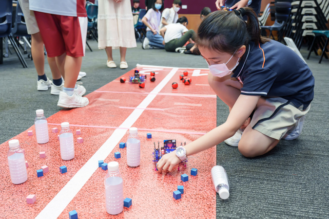A student tested the spider robot on the game field.
