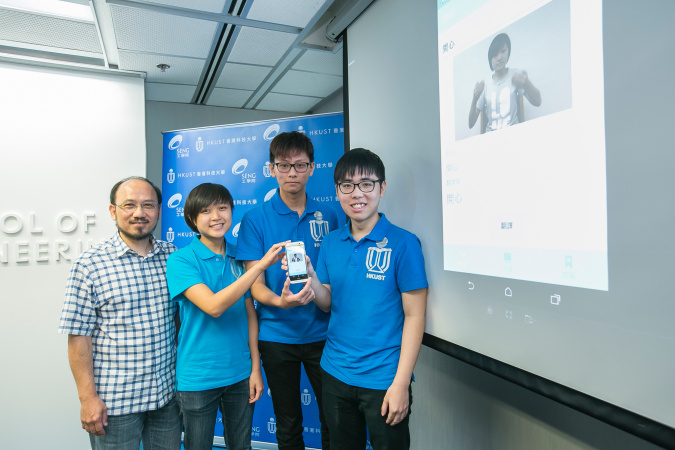 (from left) HKUST’s Prof Brian Mak and students Mary Leung, Kelvin Yung, and Ken Lai show their app on the mobile phone.
